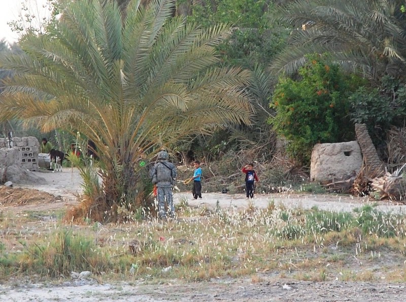 Soldier greets local children while on patrol.